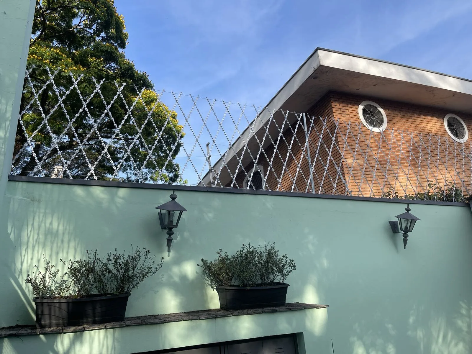 Rede navalhada instalada sobre muro de residência em São Paulo